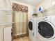 Functional laundry room equipped with a washer, dryer, shelving, and a window at 3612 Woodnotch Ct, Charlotte, NC 28269