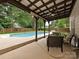 Covered patio area overlooking a sparkling in-ground pool and private backyard at 3612 Woodnotch Ct, Charlotte, NC 28269
