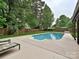 Backyard view of the in-ground swimming pool surrounded by a patio and lush landscaping at 3612 Woodnotch Ct, Charlotte, NC 28269