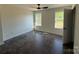 Bedroom with dark floors, two windows, ceiling fan and white walls at 4040 Daugherty Rd, China Grove, NC 28023