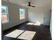 Bedroom with dark floors, two windows, ceiling fan, and white door at 4040 Daugherty Rd, China Grove, NC 28023