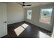 Bedroom with dark floors, two windows, ceiling fan and white walls at 4040 Daugherty Rd, China Grove, NC 28023