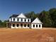 Newly constructed two-story home with black trim, covered porch and wooded backdrop at 4040 Daugherty Rd, China Grove, NC 28023