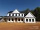 Newly constructed two-story home with black trim, covered porch and wooded backdrop at 4040 Daugherty Rd, China Grove, NC 28023