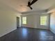 Bright main bedroom featuring a tray ceiling, modern ceiling fan, and abundant natural light from two large windows at 4040 Daugherty Rd, China Grove, NC 28023