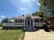 Charming gray home with a covered porch, black shutters and a quaint, inviting front yard at 406 S Catawba St, Lancaster, SC 29720