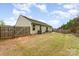 Fenced backyard with a patio, and chairs, and solar panels atop the roof at 4219 Mackinnon Dr, Charlotte, NC 28214