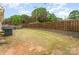 Fenced-in backyard featuring an AC unit, patio furniture, and a combination of grass and mulch at 4219 Mackinnon Dr, Charlotte, NC 28214
