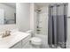 A well-lit bathroom featuring a modern vanity, toilet, and a shower-tub combination with a patterned curtain at 4219 Mackinnon Dr, Charlotte, NC 28214