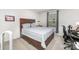 Comfortable bedroom with wood-look bed frame, blue striped bedding, and a well-lit workspace near a window at 4219 Mackinnon Dr, Charlotte, NC 28214