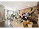Elegant living room with brick accent wall, grand piano, and stylish contemporary furnishings at 423 N Pine St, Charlotte, NC 28202