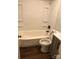 Simple bathroom featuring a tub, toilet, and vanity with dark floors at 424 Skyland Ave, Charlotte, NC 28205