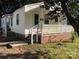 Charming home featuring a brick foundation, white railings, and a cozy porch area with nearby mature tree at 424 Skyland Ave, Charlotte, NC 28205