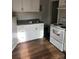 Kitchen with white cabinets, laminate countertops, a stainless steel sink, and an electric stove at 424 Skyland Ave, Charlotte, NC 28205