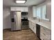 Bright kitchen with white cabinets, stainless appliances, and a farmhouse sink, ideal for culinary enthusiasts at 507 Chrysler St, Kannapolis, NC 28083
