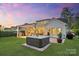 Outdoor hot tub adjacent to a covered patio with seating and a grill in a manicured yard at 5490 Sapwood Ct, Denver, NC 28037