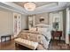 Elegant bedroom with a decorative chandelier, tray ceiling, and patterned bedding at 5490 Sapwood Ct, Denver, NC 28037