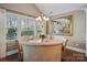 Charming dining area with natural light, elegant chandelier, and serene backyard views at 5490 Sapwood Ct, Denver, NC 28037