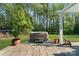 Backyard patio with hot tub and wood pergola surrounded by green grass and mature trees at 5490 Sapwood Ct, Denver, NC 28037