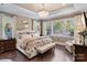 Serene main bedroom with a decorative chandelier, large windows, and a cozy seating area at 5490 Sapwood Ct, Denver, NC 28037