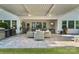 Spacious outdoor patio featuring ceiling fans, stone pavers, outdoor kitchen, tv, and comfortable seating area at 5490 Sapwood Ct, Denver, NC 28037