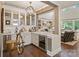 Elegant wet bar with a wine refrigerator, sleek countertops and a view into the living room at 5490 Sapwood Ct, Denver, NC 28037