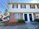 Charming two-story townhome featuring red brick and vinyl siding, complemented by red shutters and landscaped entrance at 5812 Hunting Ridge Ln # A, Charlotte, NC 28212