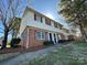 Exterior elevation of the two-story brick and vinyl home with red shutters at 5812 Hunting Ridge Ln # A, Charlotte, NC 28212