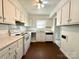 Efficient kitchen with white appliances, white cabinetry, and a breakfast bar area at 5812 Hunting Ridge Ln # A, Charlotte, NC 28212