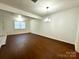 Well-lit living room with hardwood floors, white walls, and a pendant light fixture at 5812 Hunting Ridge Ln # A, Charlotte, NC 28212