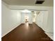 Bright living room with hardwood floors, white walls, and an open floor plan leading to the kitchen and stairs at 5812 Hunting Ridge Ln # A, Charlotte, NC 28212