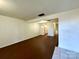 Bright living room with hardwood floors, white walls, and an open floor plan leading to the kitchen at 5812 Hunting Ridge Ln # A, Charlotte, NC 28212