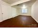 Well-lit living room with hardwood floors, white walls, and a window for natural light at 5812 Hunting Ridge Ln # A, Charlotte, NC 28212