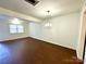 Bright living room with hardwood floors, white walls, and a pendant light fixture at 5812 Hunting Ridge Ln # A, Charlotte, NC 28212