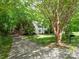 Exterior view showcasing a traditional-style home with an extended driveway and lush landscaping at 6100 Hunter Ln, Weddington, NC 28104