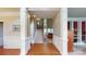Elegant foyer with hardwood floors, a staircase, and decorative columns offering a view into the living spaces at 6100 Hunter Ln, Weddington, NC 28104