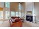The living room features a fireplace, large windows, and a leather couch surrounding a round coffee table at 6100 Hunter Ln, Weddington, NC 28104