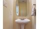 Cozy powder room with a pedestal sink, mirror, and neutral color scheme at 6100 Hunter Ln, Weddington, NC 28104