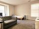 Bedroom area featuring carpet, two windows and a grey sofa at 6234 Rosecroft Dr, Charlotte, NC 28215