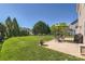 Backyard patio area with dining table, chairs, and an umbrella, surrounded by lush, landscaped yard at 639 Lorain Nw Ave, Concord, NC 28027