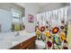Bathroom features a floral shower curtain, window, and light wood vanity at 639 Lorain Nw Ave, Concord, NC 28027