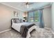 Comfortable bedroom features a ceiling fan, a large window with curtains, and a bed with pillows at 639 Lorain Nw Ave, Concord, NC 28027