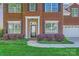 Close-up of the brick home's entrance with manicured bushes and a well-kept lawn at 639 Lorain Nw Ave, Concord, NC 28027