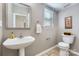 Neat half bath featuring a pedestal sink, framed mirror and neutral wall color at 639 Lorain Nw Ave, Concord, NC 28027