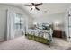 Main bedroom boasts plush carpet, ceiling fan, and window with sheer white curtains at 639 Lorain Nw Ave, Concord, NC 28027