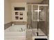 Bright bathroom featuring a tub, separate shower, tiled surround, and contemporary fixtures at 705 Hinterland Ln, Matthews, NC 28104