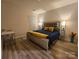 Bedroom featuring wood floors, neutral walls and a bed with a decorative headboard and lamps at 705 Hinterland Ln, Matthews, NC 28104