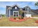 Beautiful home featuring blue siding, white trim, and a well-maintained lawn at 705 Hinterland Ln, Matthews, NC 28104