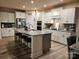 Open kitchen features a large center island with granite countertops, stainless steel appliances, and bar stool seating at 705 Hinterland Ln, Matthews, NC 28104
