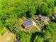 Aerial view of a home with a solar panel array on roof and pool surrounded by lush greenery at 7122 Forest Ridge Rd, Matthews, NC 28104